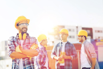group of smiling builders in hardhats outdoors