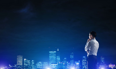 Businessman viewing night glowing city