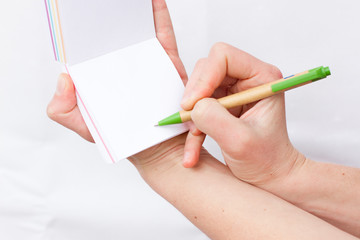 Hand holds notebook open. Blank white paper. Place for an inscription