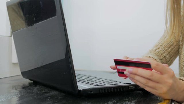 Close up shot. Young woman buying goods from the internet and entering number security code from credit card on laptop. Online, technology and internet concept.