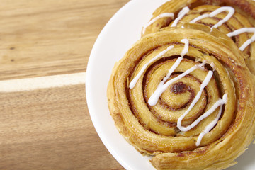 A plate of freshly baked cinnamon swirls on a wooden kitchen counter background