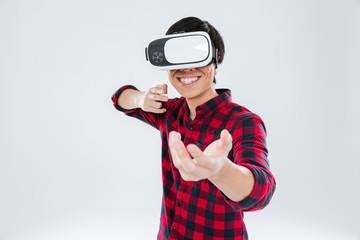 Happy man wearing virtual reality device and holding imagined gun