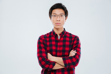 Young man in casual shirt standing with arms crossed