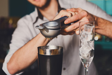 Barman's hands making cocktail with lime