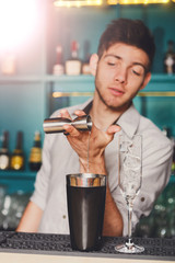 Barman's hands making alcohol cocktail
