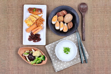 Closeup rice gruel with sausage, fried vegetables and stewed egg