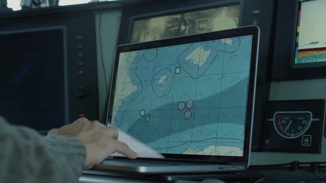 Captain of Commercial Fishing Ship Surrounded by Monitors and Screens Working with Sea Maps in his Cabin.  Shot on RED Cinema Camera in 4K (UHD). 
