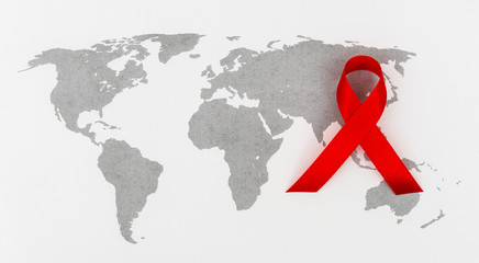 Aids Awareness Red heart Ribbon on world map .