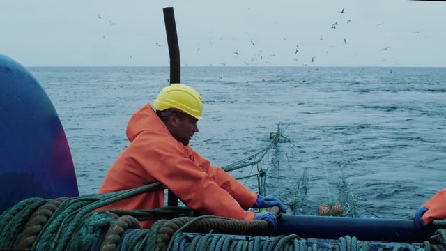 Crew of Fishermen Work on Commercial Fishing Ship that Pulls Trawl Net.  Shot on RED Cinema Camera in 4K (UHD). 