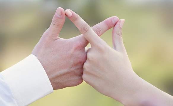Close-up of caucasian people holding hands in an infinity shape.