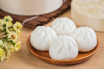 Steamed buns on wooden plate and bamboo basket