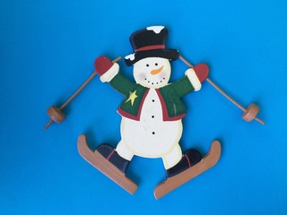 Cute snowman play ski on blue background