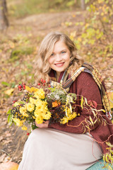 Cute woman with a bouquet of flowers in autumn park