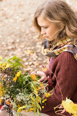 Cute woman with a bouquet of flowers in autumn park