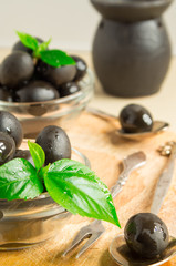 Black olives in oil on a wooden background