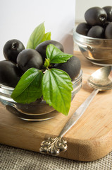 Black olives in a glass bowls on the old vintage tablecloths