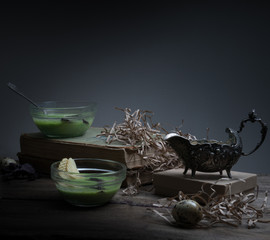 vintage, Provence. spinach soup in a glass bowl on rough rustic table. chips, quail egg, old silver vase