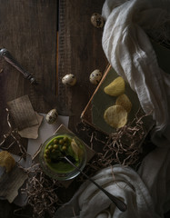 vintage, Provence. spinach soup in a glass bowl on rough rustic table. chips, quail egg