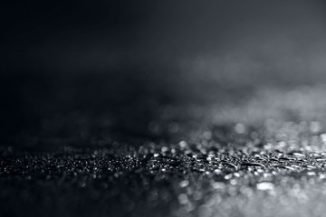 Abstract black and white background with shiny brilliant water drops, dew or rain on the glass with...
