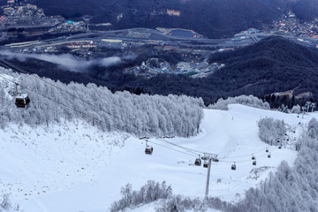 Cableway gondola ski lift gondola on a snowy mountain slope background beautiful winter scenery