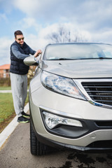 A man cleaning car with microfiber cloth, car detailing (or valeting) concept