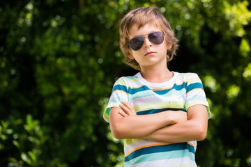 A little boy is wearing sun glasses