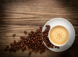 coffee cup and beans on old wooden background.