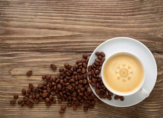 coffee cup and beans on old wooden background.