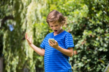 A little boy is angry with his mobile phone