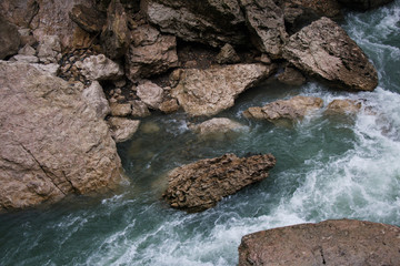 Landscape of rapid mountain river flowing between rough stones. Cold colors