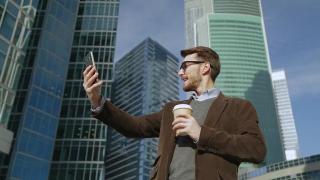 Attractive man takes selfie on smartphone