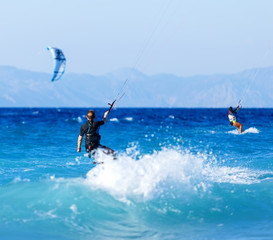 young woman kite-surfer rides in summer day