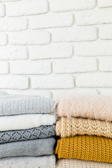 Fototapeta na wymiar Stack of white cozy knitted sweaters