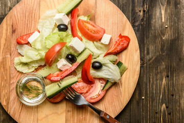 Ingredients of Fresh vegetable salad on olive wood cutting board