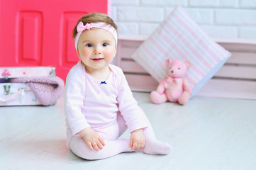 Cute little girl wearing pink clothes and trendy headband with a bow