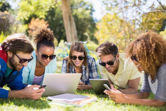 Group Of Friends Using Laptop, Mobile Phone And Digital Tablet