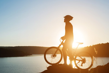 Silhouette of a man on mountain-bike during sunset.