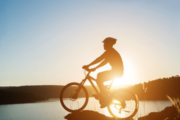 Fototapeta na wymiar Silhouette of a man on mountain-bike during sunset.
