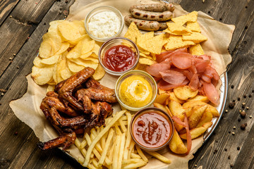 wide selection of snacks for beer with different sauces on parchment top view