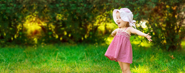Smiling little girl in a meadow in the park.
