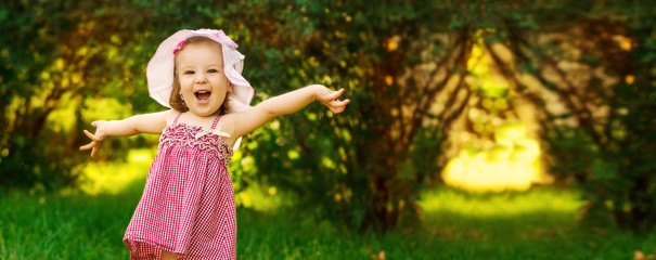 Smiling little girl in a meadow in the park.