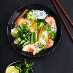 asian rice noodle, shrimps and vegetable soup in bowl