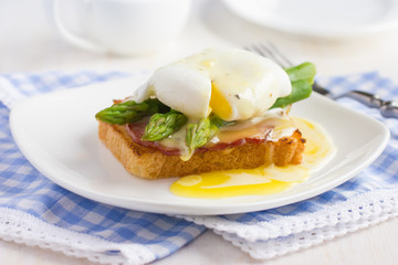 Eggs Benedict with hollandaise sauce on toast with  bacon and as