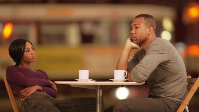 Black couple at outdoor cafe at night having an argument