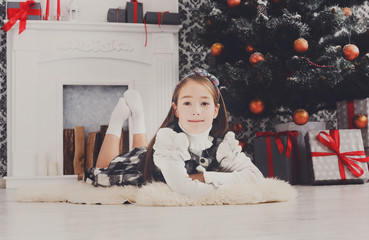 Beautiful child girl and christmas present indoors