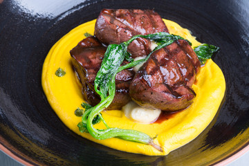 Grilled steak served with yellow humus