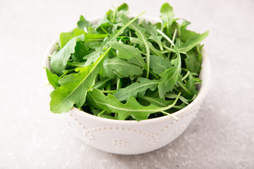 fresh arugula salad on a grey stone background