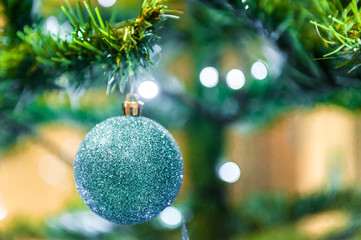 Christmas ball on the Christmass tree in the background with other ukrasheniyi and garlands. copyspace.