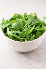 fresh arugula salad on a grey stone background