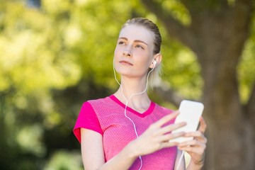 Fototapeta premium Piękna kobieta słuchania muzyki w telefonie komórkowym